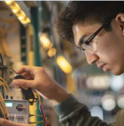Student connecting wires in Electrical Technology program