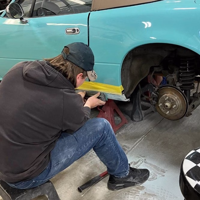 Auto Collision student working on shiny sports car