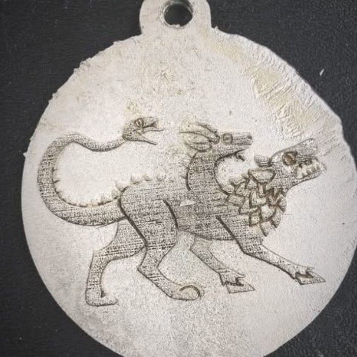 A medalilon made on the glowforge and cast in pewter