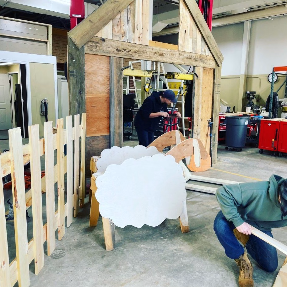 Foundations of Tech students working on farmhouse scene built out of wood