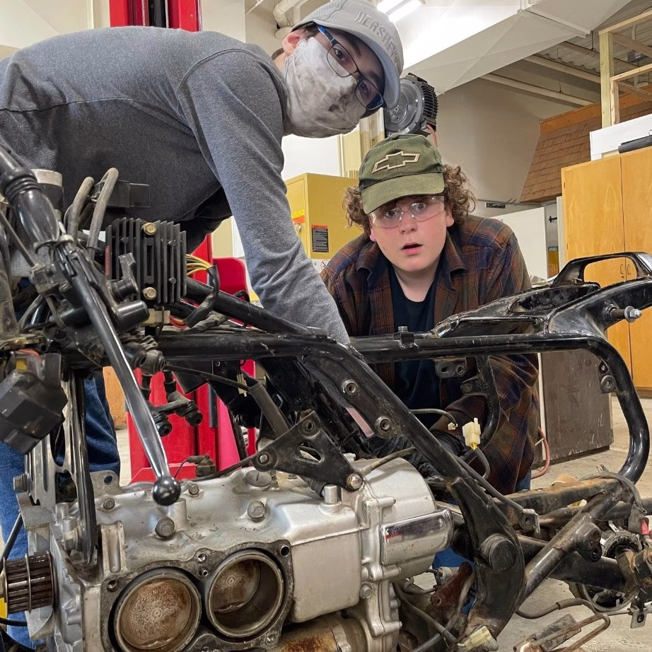 Foundations students working on bike engine