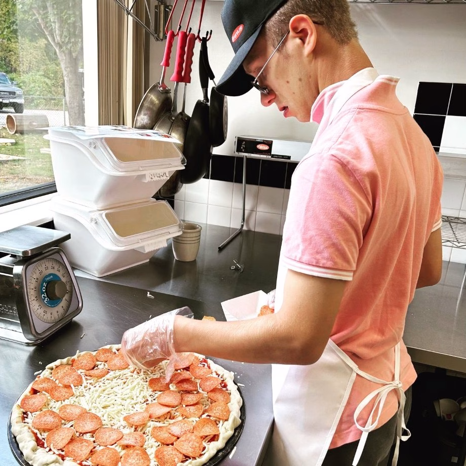 General trades student making a pizza