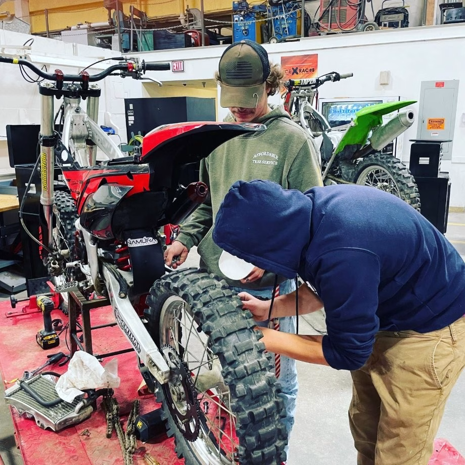 Two students work on motorbike